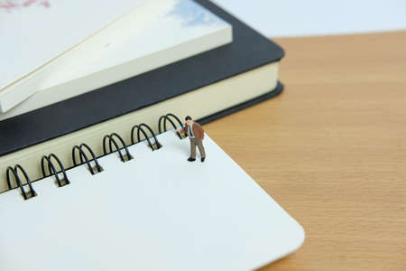 Miniature business concept - writing a resolution list. Mini figure with black white notesの写真素材