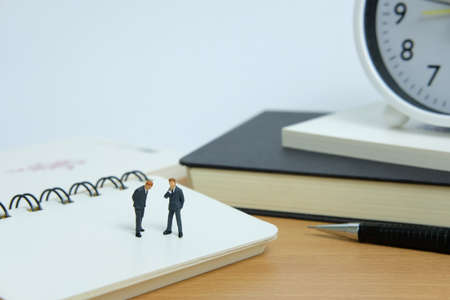Miniature business concept - thinking a resolution. Mini figure with black white notesの写真素材