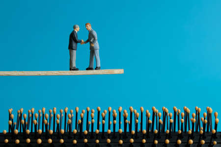 Miniature business concept - two businessman make partnership strategy for risk management transferの写真素材