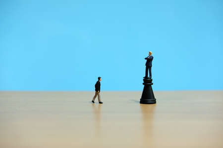 Business strategy conceptual photo - miniature businessman standing on castle chess pieceの写真素材