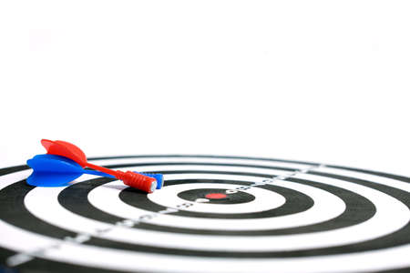 Wooden dartboard with red blue arrow on white background