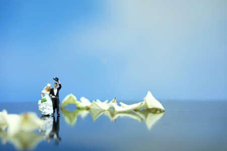 Miniature photography outdoor marriage wedding concept, bride and groom walking on white rose flower pileの写真素材