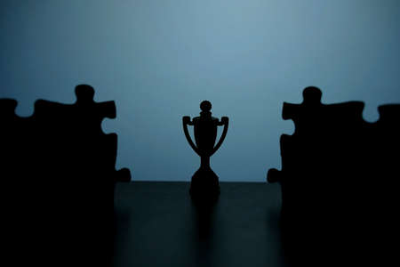 Business strategy conceptual photo â Silhouette of trophy stand in the middle of jigsaw puzzleの写真素材