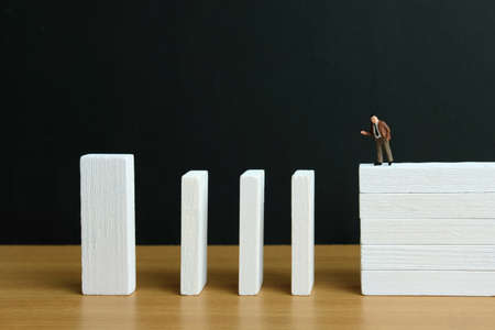 Business strategy conceptual photo - Miniature of businessman stands at the edge of wooden bridge staircaseの写真素材