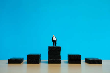 Business strategy conceptual photo - Miniature of businessman stands on a podiumの写真素材