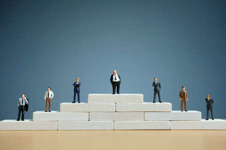 Business strategy conceptual photo - Miniature of businessman stands on a podiumの写真素材