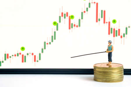 Miniature people toy photography. An angler standing above coin money stack searching investment...