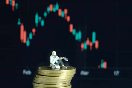Miniature tiny people toys photography. People become poor because the stock market crashの写真素材
