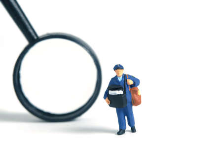 Miniature people toys conceptual photography. Address location searching. Postman courier with...