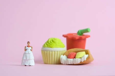 Woman dieting from junk food before wedding day concept. Miniature people toys photography, girl holding wedding dress. Image photoの写真素材