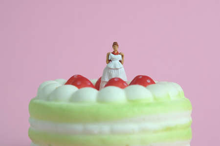 Woman dieting from cake before wedding day concept. Miniature people toys photography, girl holding wedding dress. Image photoの写真素材