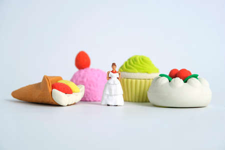 Woman dieting from cake before wedding day concept. Miniature people toys photography, girl holding wedding dress. Image photoの写真素材