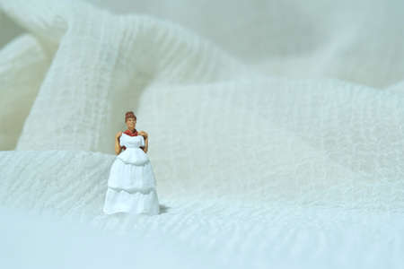 Women miniature people trying to choose wedding dress. Image photoの写真素材