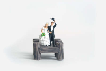 Wedding and marriage newlywed couple concept miniature people toy photography. Bride and groom standing above wooden bridge. Image photoの写真素材