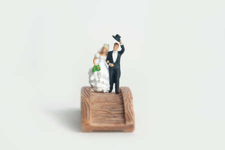 Wedding and marriage newlywed couple concept miniature people toy photography. Bride and groom standing above wooden bridge. Image photoの写真素材