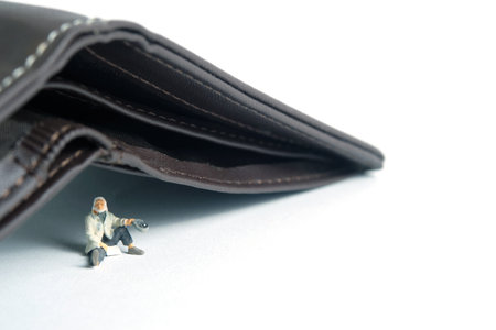 Poor man beggar with empty wallet no money cash. Miniature tiny people toys photography. isolated on white background.の写真素材