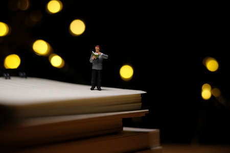 home schooling, children reading book alone on quarantine or isolation time at night. Miniature tiny...