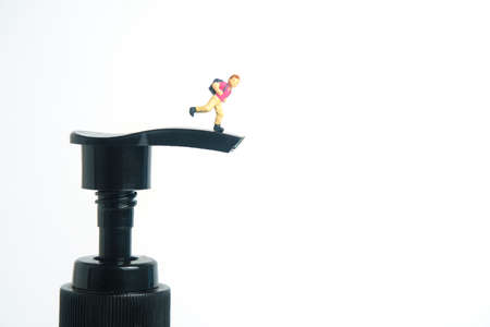 Reopen school class on virus pandemic. Children or kids, walk above disinfectant hand sanitizer bottle. Miniature tiny people toys photography. isolated on white background.の写真素材