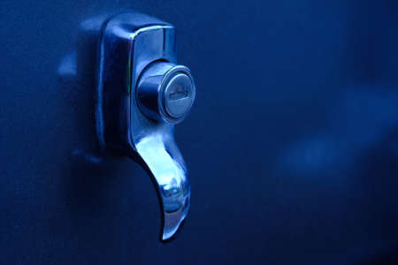 Automotive detail macro photography. Close up of silver car keyhole with blue light. cold toneの写真素材