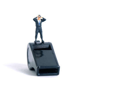 Businessmen using binoculars standing above black whistle. Miniature tiny people toys photography....