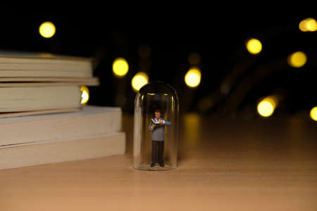 home schooling, children reading book alone on quarantine or isolation time at night. Miniature tiny people toys photography with bokeh light backgroundの写真素材