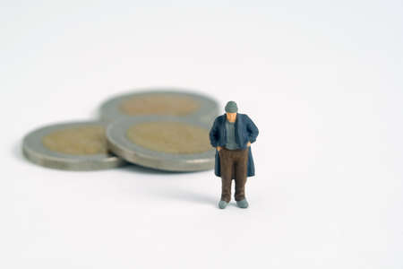 Poor man with coin money left. Miniature tiny people toys photography. isolated on white background.の写真素材