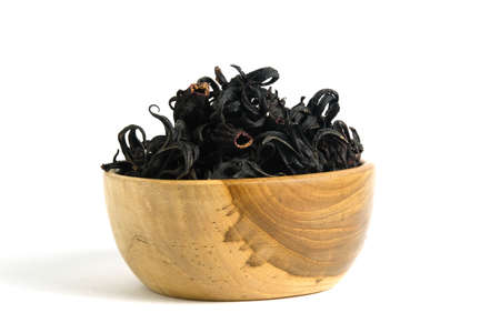 Pile of dried Rosella flower ( Hibiscus sabdariffa ) in a wooden bowl isolated on white background. Image photoの写真素材
