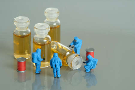 Miniature people toy figure photography. Vaccine clinical trial test. A group of paramedics with...