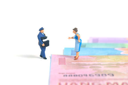 Miniature people toys conceptual photography. COD (Cash on delivery) service. Postman courier with cash money paper, isolated white background.の写真素材