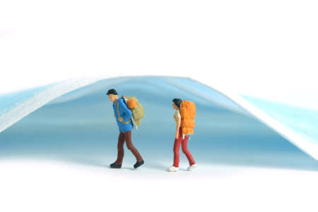 Miniature people toy photography. Safety travel concept, Backpacker and hiker traveller figure with...