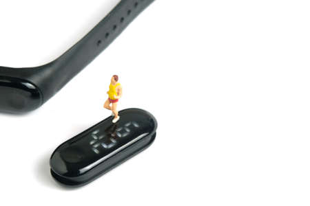 Miniature people toy figure photography. Run jogging monitoring app. A fat men running above smartwatch, isolated on white background. Image photoの写真素材