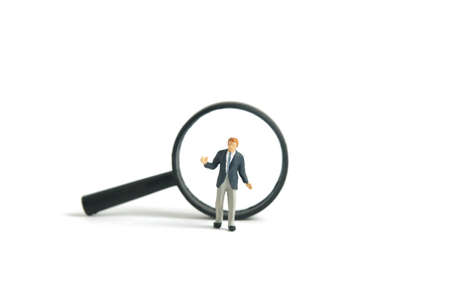 Miniature people toy figure photography. A shrugging businessman finding solution standing in front...