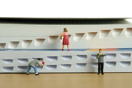 Miniature people toy figure photography. Bookshelf library concept. A group of student pupil...