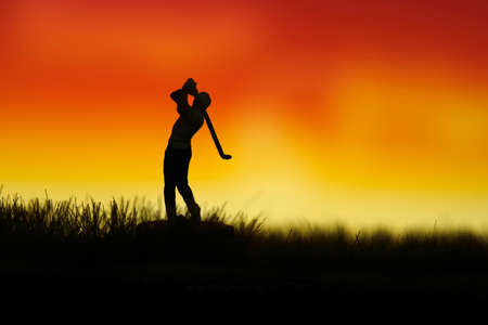Miniature people toy figure photography. Silhouette of men golfer swing his stick at meadow field hill when sunset sunrise. Image photoの写真素材