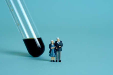 Coronavirus vaccination, elderly, old, middle-aged, senior people receive a vaccine on a tube. Miniature people toys conceptual photography.の写真素材