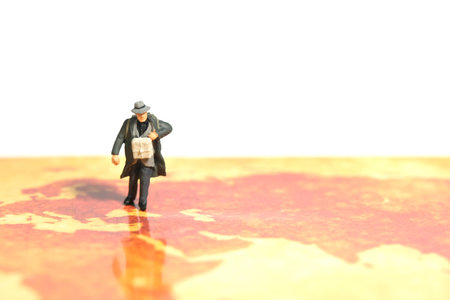 Miniature people toy figure photography. A man refugee walking above map, moving out from their country because of war conflict. Distance traveled concept. Image photoの写真素材