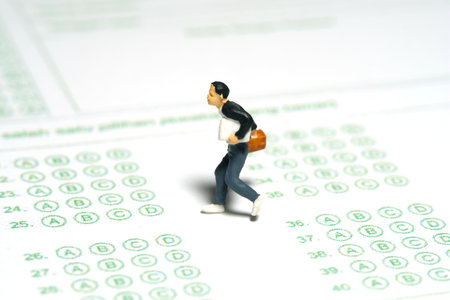 Miniature people toy figure photography. Late to attend examination day concept. Men pupil running...