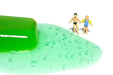 Miniature people toy figure photography. Creative summer vacation concept. Brother and sister looking on green watermelon melting ice cream. Isolated on white background. Image photoの写真素材