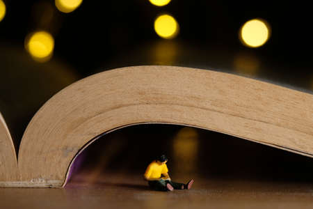 home schooling, children reading book alone on quarantine or isolation time at night. Miniature tiny...