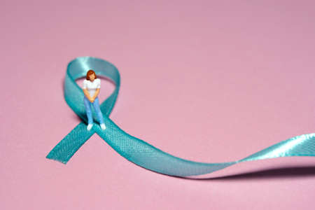 Miniature people figure toys photography. Ovarian cancer awareness day concept. Girl, teenage, woman...