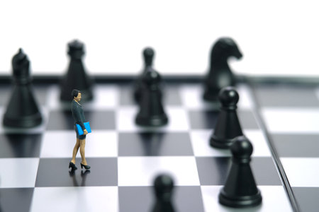 Miniature people toy figure photography. A businesswoman walking above chessboard in the middle of chess piece. Isolated on white background. Image photoの写真素材