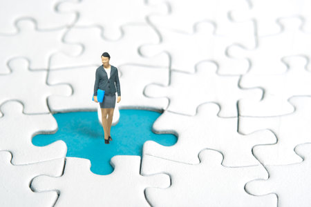 Miniature people toy figure photography. A businesswoman standing above missing piece of puzzle jigsaw. Image photoの写真素材