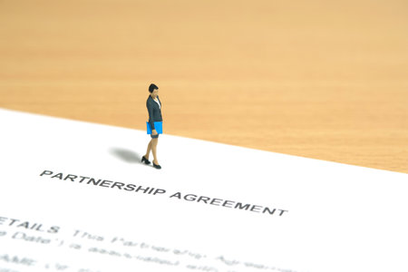 Miniature people toy figure photography. Business partner contract sign concept. A businesswoman walking above partnership agreement file document. Image photoの写真素材
