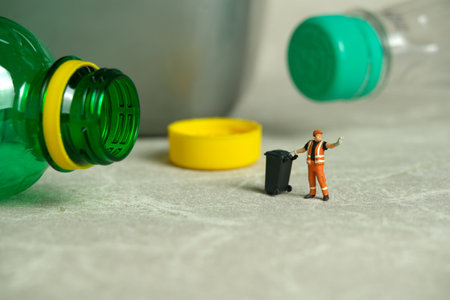 Miniature people toy figure photography. Cleaning workers walk among plastic drink bottles scattered...