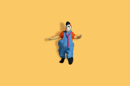 Miniature people toy figure photography. Full body of a clown wearing tie and jumper suit. Isolate...