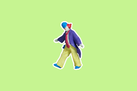 Miniature people toy figure photography. Side view full body of a clown wearing huge tie and suit. Isolate on green background. Image photoの写真素材