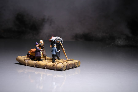 Miniature people toy figure photography. A group of poor family grandpa, grandma, and two grandchildren riding tree trunk raft at the night. Image photoの写真素材