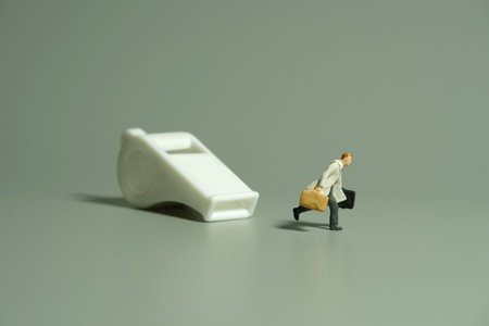 Miniature people toy figure photography. Whistle blower concept illustration. A businessman running...