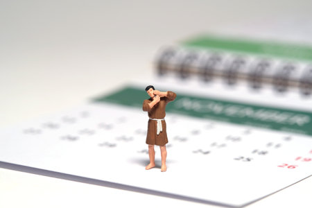 Miniature tiny people toy figure photography. A man wearing bathrobe getting shaving his beard standing above calendar. Isolated on white background. Image photoの写真素材