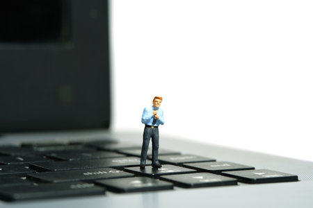 Miniature tiny people toy figure photography. A businessman getting ready, justify the tie standing...